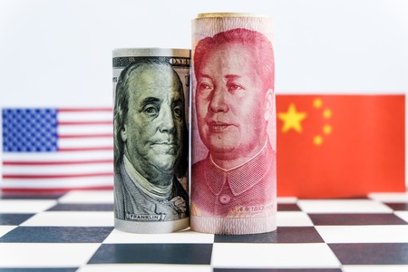 America dollar and Yuan banknote with USA and China flags. Its is symbol for tariff trade war crisis between biggest economic country in the world.の写真素材