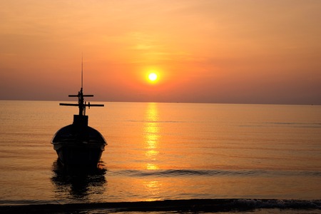Beautiful sunrise with fishing boat and the beachの写真素材