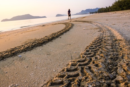 Trace or mark from tire of vehicle which someone drive on the sand beach. Copy space and unbalanced photo concept.の写真素材