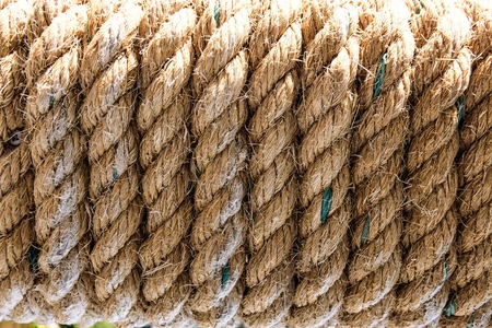Brown rope roll which it was roll on wood for add more strength for background texture concept.の写真素材