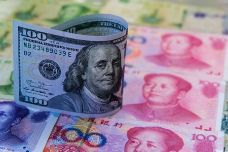 US Dollar banknote standing above Chinese Yuan banknotes. United state of america and China have war trade which both countries increase tax for trade tariff barrier.の写真素材