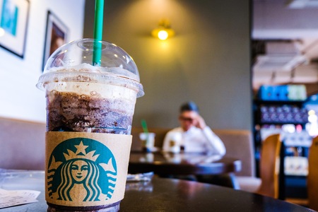 BANGKOK,THAILAND - JUNE 5,2018: The Starbucks ice coffee with cream on table. Starbucks is the meeting point for office employees for discussion and working.のeditorial素材