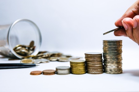 Male hand putting coins tacking  and growing the saving money and business with white background...