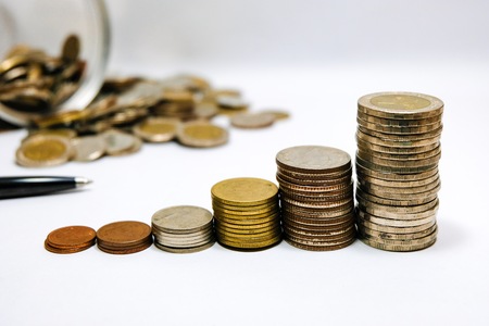 Stacking coins money growing increasing on white background for saving and business investment concept.の写真素材