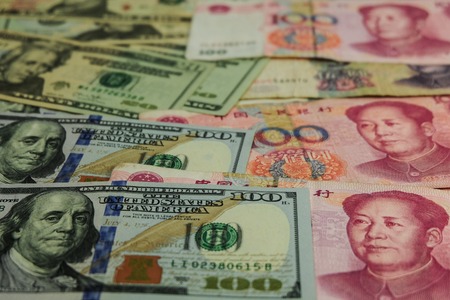 US dollar bill and China yuan banknote . America is debtor of China and now China get balance of trade with USA. so USA will increase tax for goods from China.の写真素材