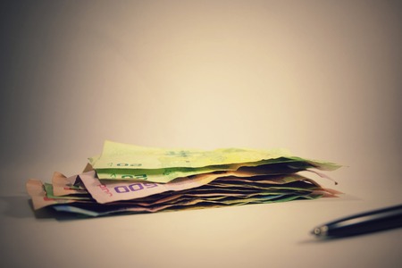 Pile of multi color euro crumpled banknote with pen on white background for saving and investment concept.の写真素材