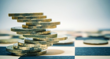 Euro coins stacked on checkers table for economy or investment concept.