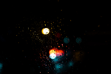 Red blue and yellow light bokeh dots on dark backgroundの写真素材