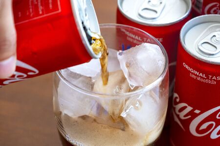 BANGKOK, THAILAND - OCTOBER 23, 2018: Coca-Cola with ice in glass and cans. Coca-Cola is a carbonated soft drink sold in stores and restaurants throughout the world.のeditorial素材