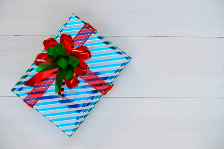 Christmas and Happy new year composition, Christmas present gift boxes with red ribbon on wooden white background. Flat lay, top view, copy space.の写真素材