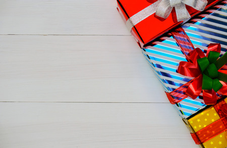 Christmas and Happy new year composition, Golden Christmas present gift boxes with red ribbon on wooden white background. Flat lay, top view, copy space.の写真素材