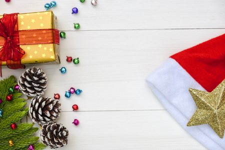 Christmas and Happy new year composition, Christmas present gift boxes,pine cones, fir branches, red christmas hat , golden star on wooden white background. Flat lay, top view, copy space.の写真素材