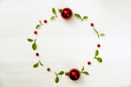 Christmas and Happy new year composition. Wreath from green leaf and red ball on white background. Flat lay, top view, copy space use for template and greeting card.の写真素材