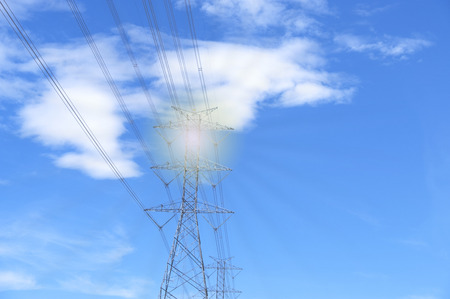 High voltage of electricity pole with cable on clouds blue sky and sun light.の写真素材
