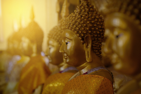 Close up beautiful brass metal Buddha statue endways with orange sunlight.Religion and peaceful concept.の写真素材
