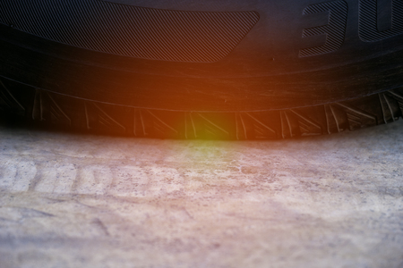 Close up black tire or tyre on cement road with sunlight.の写真素材