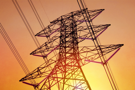 High voltage of electricity pole with cable on yellow sky and sunlight.Technology concept.の写真素材