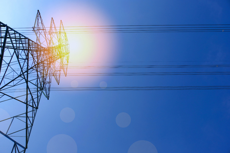 High voltage of electricity pole with cable on clouds blue sky and sun light.の写真素材