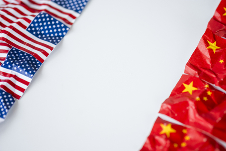 Wrinkle of USA and China flag on sky background. It is symbol of United states of America and China tariff trade war and tech war crisis between biggest economic country in the world.の写真素材