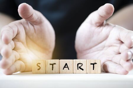 2 Hand push start keyword on wooden cubics. It is begin of positive mindset.の写真素材