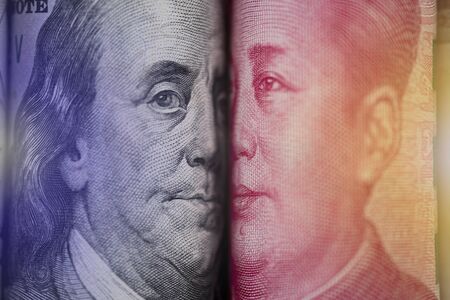 Face to face of Benjamin Franklin and Mao Tse tung from US dollar and China Yuan banknote. It is...