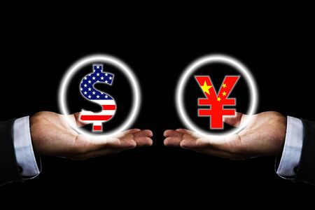 US dollar and China Yuan sign on hand of businessman with black background. It is symbol of economic tariff trade war and reduce exchange currency between USA and China.の写真素材