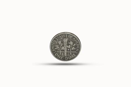 Closeup of one dime coin with shadow on white background. US dollar is worldwide currency and...