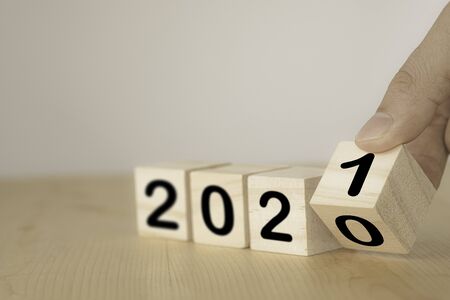 Hand flipping wooden blocks for change year  2020 to 2021 . New year and holiday concept.