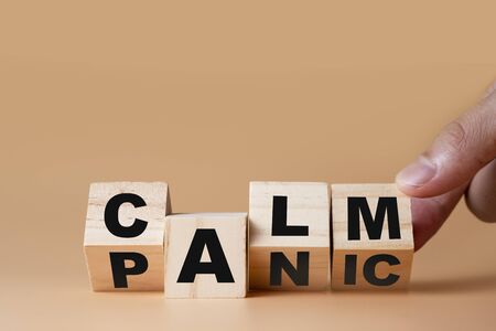 Hand flipping wooden cubes for change wording" Panic "  to " Calm".  Mindset is important for human development.の写真素材