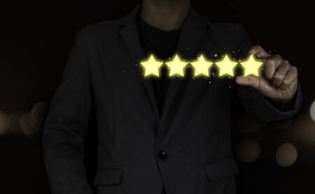 Customer hand putting to yellow illustration 5 stars virtual screening monitor for satisfaction evaluation survey and review.の写真素材
