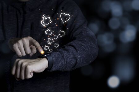 Hand touching on smart watch to push like and  Love icon. Technology concept.