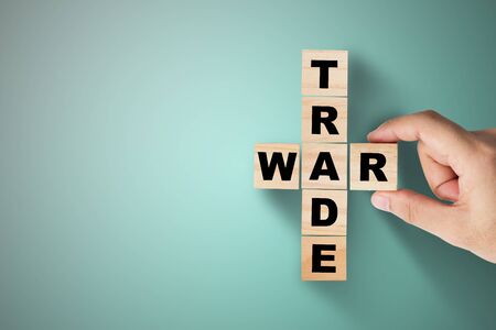 Hand putting trade war wording on green background.の写真素材
