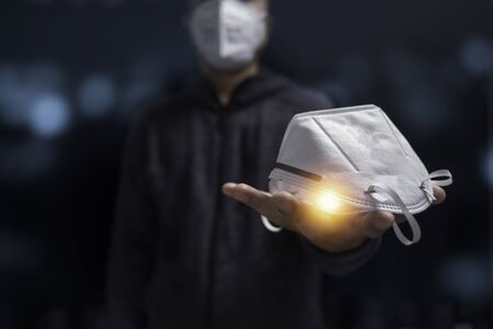 Man wear and give N95 surgical face mask to prevent and stop COVID19 pandemic. Health and medical concept.の写真素材