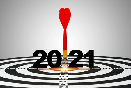 One red dart arrow hit on 2021 of  centre target of dartboard. It is symbol for business hitting to achieve target in 2021 year.の写真素材