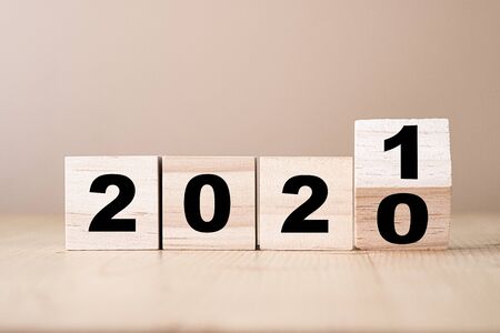 Hand flipping wooden blocks for change year  2020 to 2021 . New year and holiday concept.の写真素材