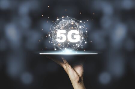 Hand holding tablet with 5G  and virtual global connection line. communication technology...