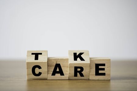 Flipping of take care yourself wording which print screen on wooden cubes blocks on table.の写真素材