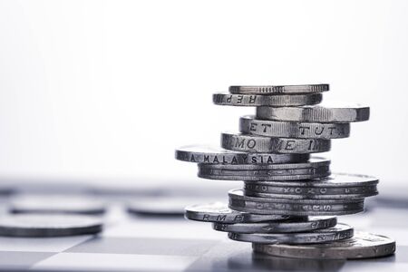 Alternate design coins stacking on white background. Dividend and profit from saving and investment...