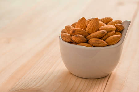 Closeup isolated of fresh almonds nut seed with green leaves on white background.の写真素材