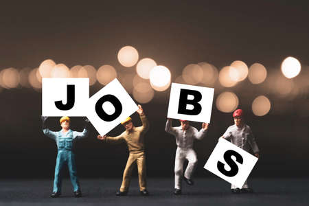 Find and searching jobs due to economic depression crisis concept ,Miniature figures workers rise up and showing jobs wording with orange background.の写真素材