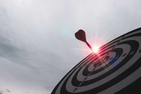 Dart arrow hit dartboard and goal with sunlight ,Setup objectives and target for business investment...