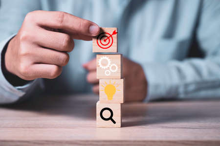 Achievement business target concept , businessman holding and stacking wooden cubes block which...