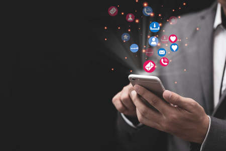 Social media and marketing concept, Businessman holding white smartphone and using colourful social...