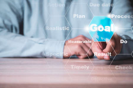 Businessman touching virtual goal wording. Business investment achievements target and objective concept.の写真素材