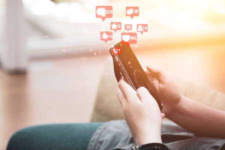 Businessman holding smartphone to use social media icon such as love like and star. Marketing and...
