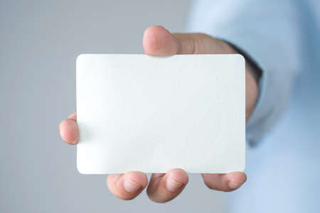 Businessman holding white paper for add text wording or message or mockup advertisement with copy...