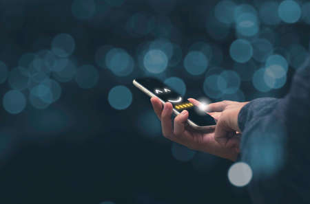 Businessman holding smartphoneand showing customer online evaluation result for five star. Customer...