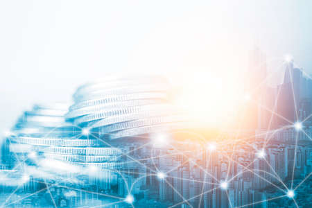 Investing and saving concept ,double exposure of coins stacking and high building with connection.の写真素材