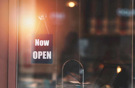 Hanging of Text " Now open" on blue sign label in front of cafe and restaurant.の写真素材