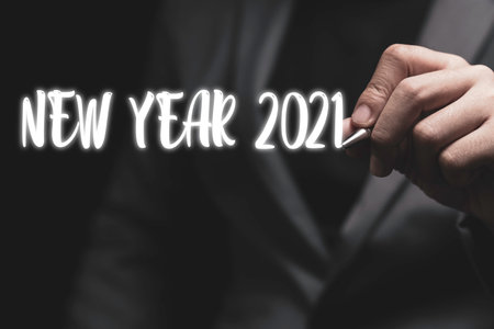 Welcome merry Christmas and happy new year in 2021, Businessman hand writing new year 2021 wording.の写真素材